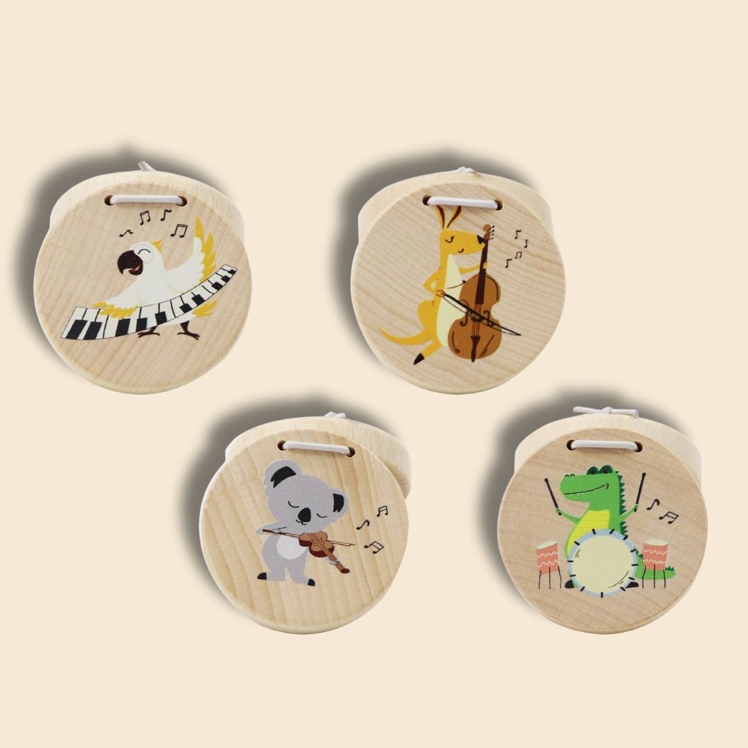 Four wooden castanet instruments with animal illustrations playing musical instruments on a beige background