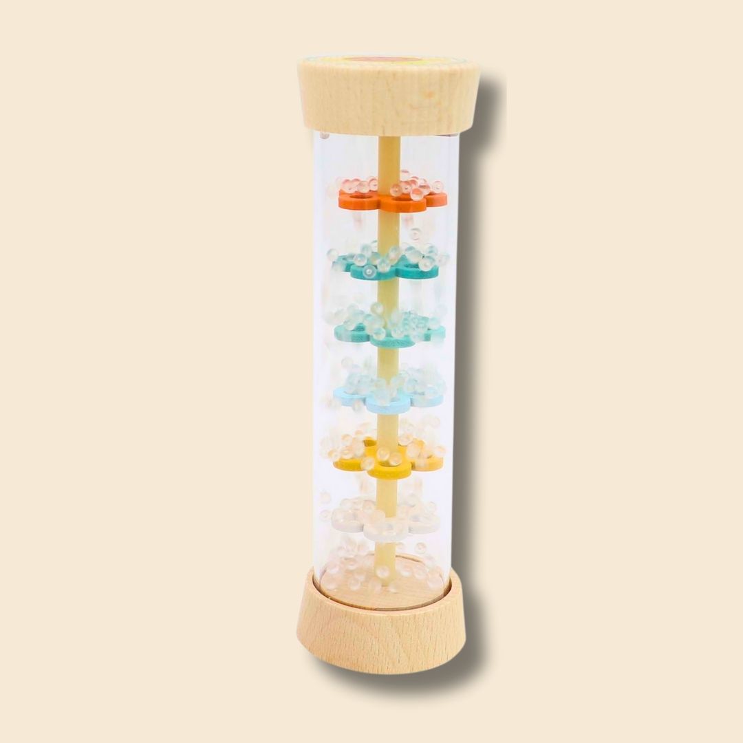 Motion shot of Hermit Crab/Turtle rainstick beads cascading down inside the musical instrument, the beads falling through levels of colourful wooden flowers inside