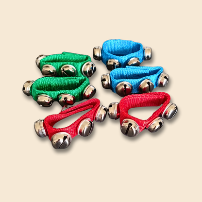 Colourful wristband bells sets with metal bells on fabric wristbands, on a beige background