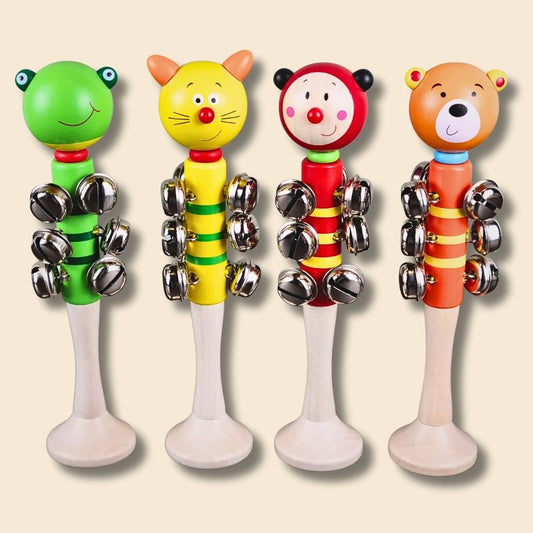 Four colourful children's animal jingle bell sticks, green frog, yellow cat, red ladybug and orange bear, on a beige background