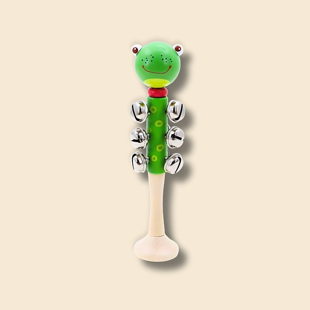 Green freckled frog wooden bell stick music instrument for kids on a beige background