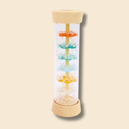 Motion shot of Hermit Crab/Turtle rainstick beads cascading down inside the musical instrument, the beads falling through levels of colourful wooden flowers inside
